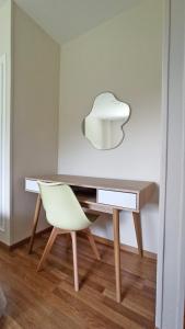 einen Schreibtisch mit einem weißen Stuhl und einer weißen Lampe in der Unterkunft HOTEL RST. PADORNELO 