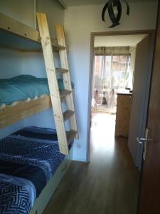 a room with two bunk beds and a door to a kitchen at Appartement en residence in Les Angles