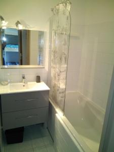 ein Badezimmer mit einem Waschbecken, einer Badewanne und einer Dusche in der Unterkunft Appartement en residence in Les Angles