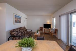 ein Wohnzimmer mit einem Sofa und einem TV in der Unterkunft Tahiti Inn in Ocean City