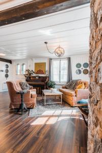 a living room with two couches and a piano at Auberge de l'Ouest in Deschambault