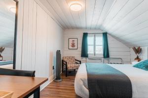 Schlafzimmer mit einem Bett, einem Schreibtisch und einem Tisch in der Unterkunft Auberge de l'Ouest in Deschambault