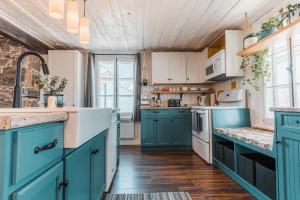 a kitchen with blue cabinets and white appliances at Auberge de l'Ouest in Deschambault