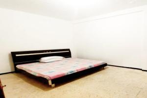 una camera con un letto su una parete bianca di OYO Life 92647 Edelweis Homestay a Tuban