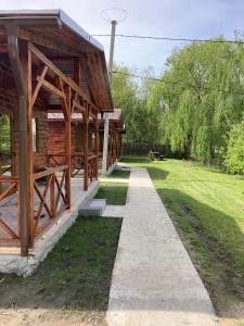 a wooden building with a pathway next to a yard at La Cotihana in Cotihana