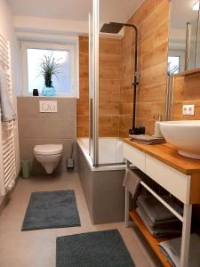 ein Badezimmer mit einem Waschbecken, einer Badewanne und einem WC in der Unterkunft Ferienwohnung Direkt Oberhof in Murg