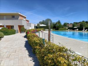 a house and a swimming pool with a fence at Grazioso in Bibione