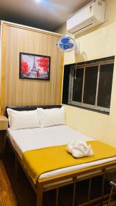 a bedroom with a bed with a yellow blanket at Casa Cabin Stay Mumbai in Mumbai