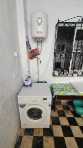 uma máquina de lavar roupa num quarto com piso em xadrez em Maison Familiale, vue sur mer à 5 minutes em Larache