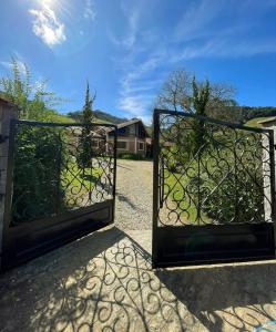 a pair of gates in a yard with trees at Toca - Bairro Serrano in São Bento do Sapucaí