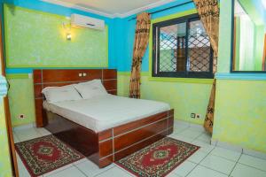 a small bedroom with a bed and a window at LAUNAPARK RESIDENCE in Douala