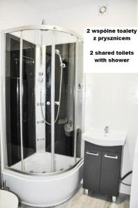 La salle de bains est pourvue d'une douche et d'un lavabo. dans l'établissement Ronus Apartments Łódź Pomorska 116 -Bezpłatny Parking, à Łódź