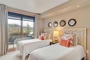 two beds in a room with a window at Edgemont 2306 - Luxury Condo - True Ski-in Ski-out Access & Winter Shuttle! in Steamboat Springs