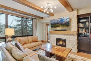 a living room with a stone fireplace at Edgemont 2306 - Luxury Condo - True Ski-in Ski-out Access & Winter Shuttle! in Steamboat Springs