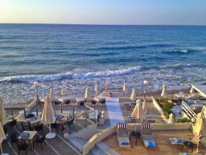 レティムノ・タウンにあるFiloxenia Beach Hotelのビーチの景色を望む客室で、椅子とパラソルが備わります。