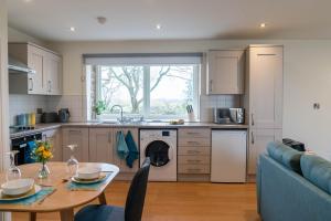 a kitchen and living room with a table and a couch at The Old Threshing Barn in Kirklington