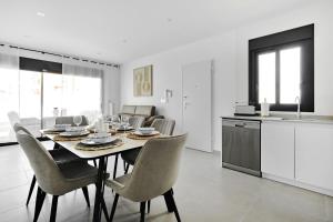 a kitchen and dining room with a table and chairs at Villa Luna in San Pedro del Pinatar