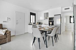 a kitchen and dining room with a table and chairs at Villa Luna in San Pedro del Pinatar +73 photos