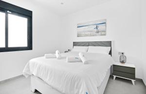 a white bedroom with a large white bed and a window at Villa Luna in San Pedro del Pinatar +73 photos