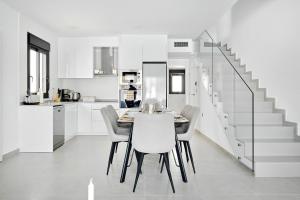 a kitchen and dining room with a table and chairs at Villa Luna in San Pedro del Pinatar