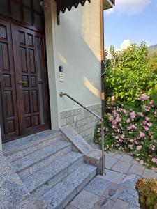 un conjunto de escaleras que conducen a una puerta con flores en Green & Blue House, en Valbrona