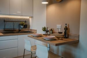 a kitchen with a counter with two chairs and a sink at Blooms Apartment in Marple +26 photos