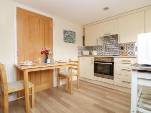 a kitchen with a wooden table and a dining room at Little Hamlin in Callington