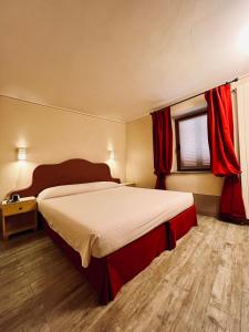 a bedroom with a large bed with red curtains at Chaledo Milagro in Ruino