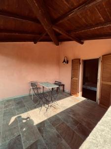 a patio with a table and chairs in a room at Chaledo Milagro in Ruino