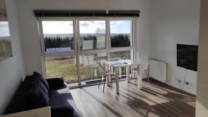 a living room with a table and chairs and a large window at Apartament Bajkowy in Sianów