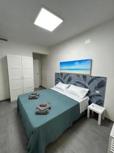 1 dormitorio con 1 cama grande con manta azul en Santorini 2.0, en San Pietro in Bevagna