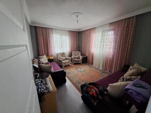 een woonkamer met een bank en stoelen in een kamer bij ORTAKÖY VİLLA in Macka