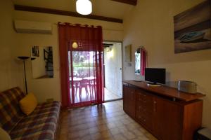 een woonkamer met een bank en een rode deur bij Villa Naturiste "EDEN" Héliovillage 105 in Cap d'Agde