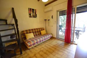 een woonkamer met een bank en een glazen schuifdeur bij Villa Naturiste "EDEN" Héliovillage 105 in Cap d'Agde