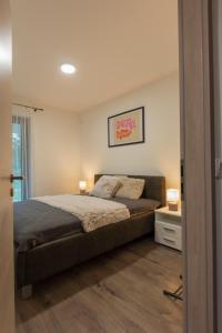 希歐福克的住宿－Római Panoráma apartman，一间卧室配有一张带两盏灯的床。