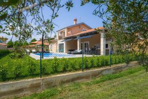 uma casa com uma piscina e uma cerca em Villa Istra Maružini by Solis Porec em Maružini