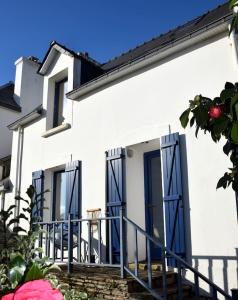 uma casa branca com portas azuis e escadas em La Maison du Pêcheur em Clohars-Carnoët