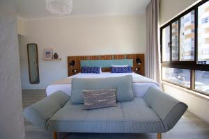 ein Schlafzimmer mit einem Bett, einem Sofa und einem Bett in der Unterkunft WOT Costa da Caparica in Costa da Caparica