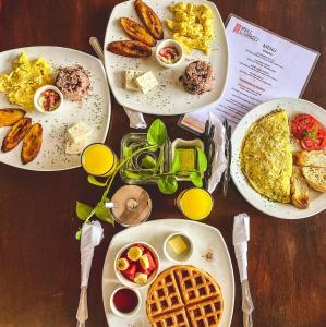 a table with plates of breakfast food on it at Hotel Real La Merced in Granada