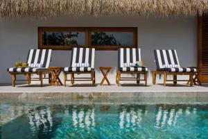 three chairs sitting next to a swimming pool at Casa Letty in Playa Blanca