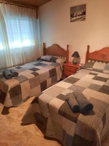 a bedroom with two beds and a window at Apartamento O CASAL in O Grove
