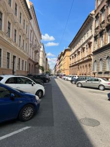 een straat met auto's aan de kant van de weg bij New York Palace Apartment in the downtown in Boedapest