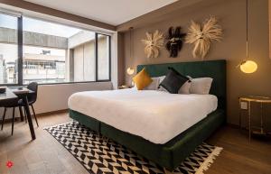 a bedroom with a large bed and a desk and a window at Casa Anatole France by Kukun in Mexico City
