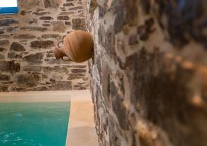 a pipe on a wall next to a swimming pool at Private Pool Dame in Mési