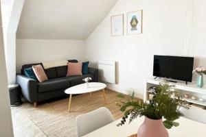 ein Wohnzimmer mit Sofa und Fernseher in der Unterkunft Appartement bord de mer centre-ville, proche gare in Le Pouliguen