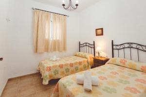 a bedroom with two beds and a window at Villa la Dehesa in Conil de la Frontera