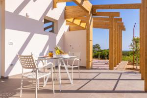 un patio con mesa, sillas y estructura de madera en Fani Rooms, en Salve
