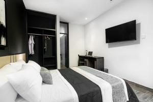 a bedroom with a bed and a flat screen tv at Rua Hoteles Piura in Piura