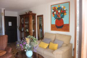 - un salon avec un canapé et un vase de fleurs dans l'établissement Casa Indalina apartamento con parking privado incluido, à Mojácar