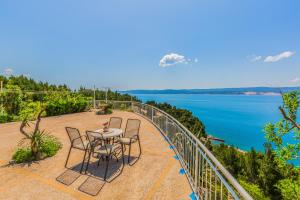 a table and chairs on a patio with a view of the water at Blu Breeze Apartments in Lokva Rogoznica +36 photos